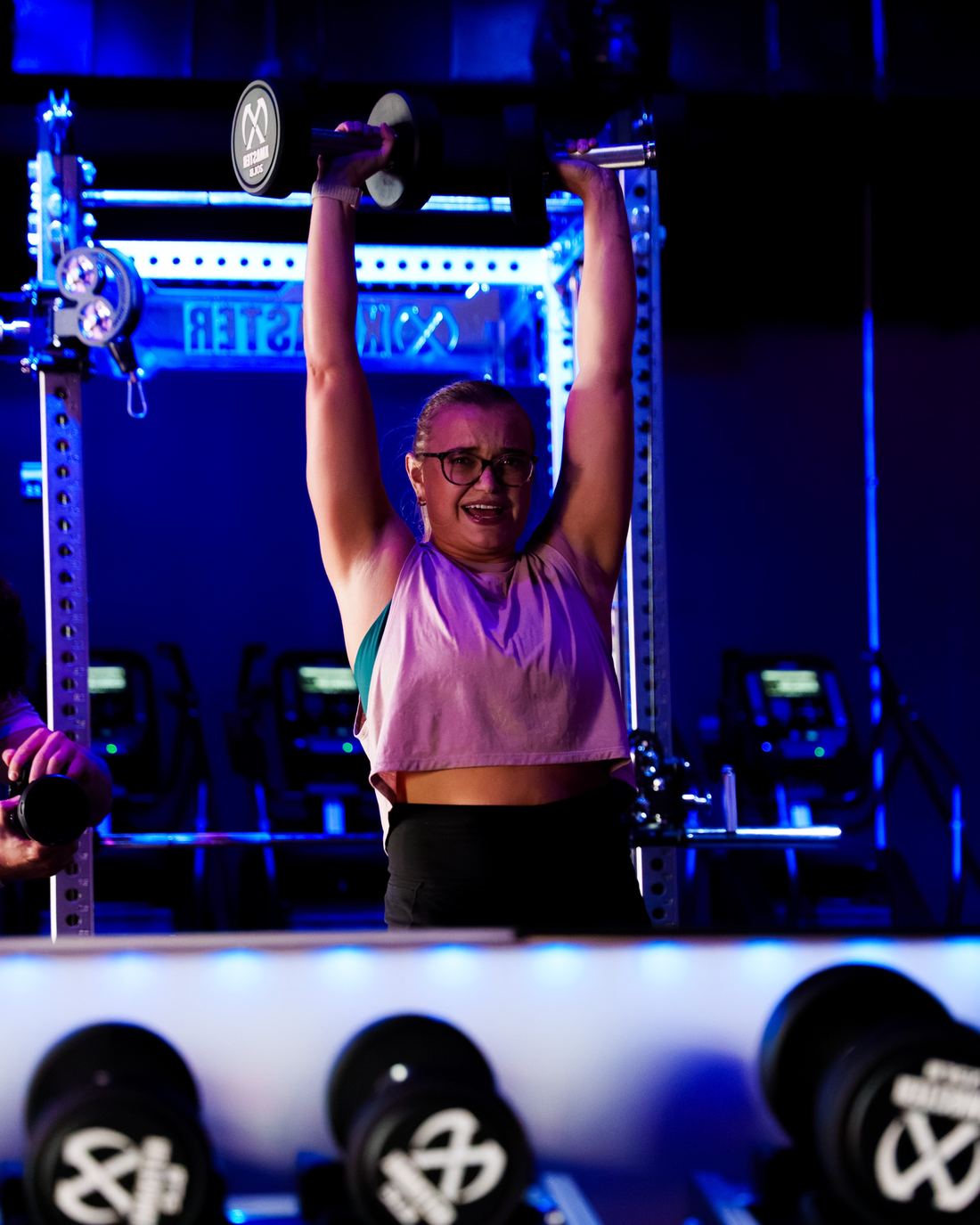 A member pressing two dumbbells overhead